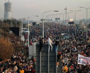 Фотографија од илјадници граѓани насобрани на булеварите во Белград. Дел од нив се качуваат на високи сообраќајни знаци.