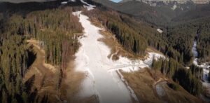 фотографија од ски-центар, покриен со снег само на скијачките патеки