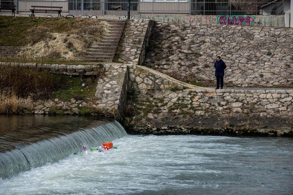 Човек кој ги набљудува шишињата кои се задржуваат во вртлозите на каскадата кај Влае, на реката Вардар.